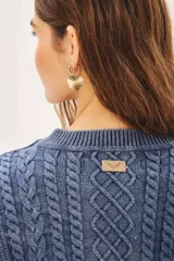 Sweater celeste de punto con diseño de trenzas, cuello redondo y corte holgado.