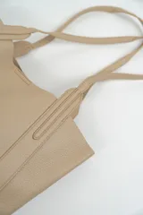 Bolso tipo tote de cuero sintético color negro, con textura granulada y doble asa de hombro.