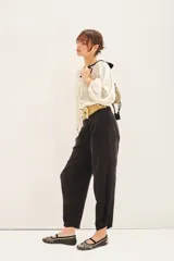 Pantalón sastrero negro con ajuste en el tobillo, tiro alto, bolsillos delanteros y traseros, pinzas en el frente. Confeccionado en cupro, similar a la seda.