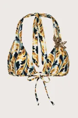 Top de bikini con estampado abstracto en tonos amarillo mostaza, negro y blanco. Diseño de cuello halter con tiras ajustables y detalle metálico dorado con forma de hoja en la unión de las copas.