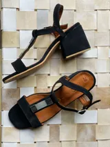 Sandalia de gamuza negra con taco bajo, aplique de nácar y alpaca, diseño cómodo y sofisticado.