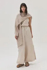Ruana beige de tejido de punto acanalado con mangas cortas.