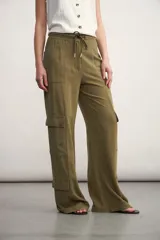 Pantalón cargo color verde oliva, de corte ancho, con bolsillos laterales con solapa y cintura con cordón ajustable.