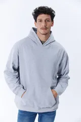 Canguro deportivo gris melange de corte oversize con capucha y bolsillo tipo canguro.