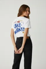 Remera blanca de algodón con estampado de texto y dibujo de naranja.