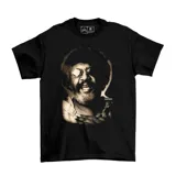 Remera negra de algodón con estampado de la cara de Rubén Rada con gafas redondas y texto 'EMEXEM' en la parte inferior.