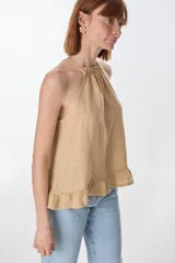 Musculosa color beige de lino, con cuello halter con volados y volados en el ruedo.