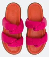Sandalias planas con tiras puffa con nudo, color fucsia y suela naranja.