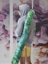 Sombrilla con estampado de hojas de palmeras y vegetación selvática en tonos verdes y celestes. Incluye funda con correa para transportar. Marca BT Merch.