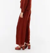 Pantalón de lino color beige, de corte recto y tiro alto, con detalle de flecos verticales.