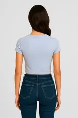 Remera cropped celeste con estampado de sol en el centro.