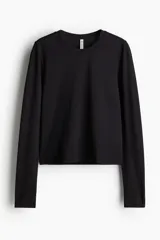Remera corta negra de microfibra suave, de ajuste entallado, con cuello redondo ribeteado y mangas largas.