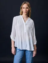 Blusa blanca de gasa bambula, marca Zac & Rachel. Cuello a la base, escote en V con apertura y botones. Largo de manga regulable con presilla y botón.
