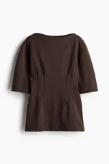 Remera larga marrón en punto pesado de algodón. Modelo con escote bote, hombros caídos y mangas amplias al codo. Cintura entallada con pinzas apenas acolchadas adelante y atrás.