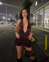 Vestido corto color vino tinto con estampado animal print sutil, escote halter profundo en V y corte en la cintura que da vuelo a la falda. Presenta un detalle de tira fina que cruza bajo el busto.