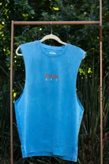 Musculosa celeste con estampado de tres hongos rojos y texto "Tuya".
