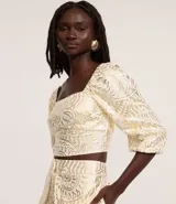 Blusa cropped de mangas 3/4, confeccionada en viscolino con 20% de lino, con escote cuadrado, elásticos en las sisas y puños. Prenda con estampa abstracta de foil.