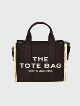 Bolso tote negro de tela jacquard con asas cortas y correa larga extraíble. Estampado frontal con el texto "THE TOTE BAG MARC JACOBS" en blanco.