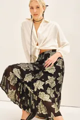 Falda larga de tiro alto con estampado floral dorado sobre fondo negro. Confeccionada en viscosa jacquard con lurex dorado, cintura elastizada con cordón ajustable, volados irregulares en el ruedo y forrería a tono.
