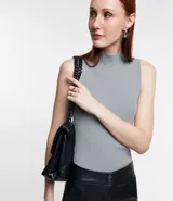 Musculosa negra de punto acanalado con cuello alto y tirantes anchos.