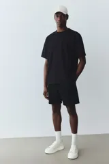 Short negro de felpa liviana de mezcla de algodón, con cintura elástica y cordón para ajustar, bolsillos al bies y un bolsillo abierto atrás.