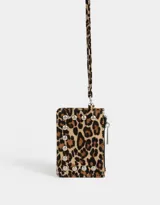 Monedero de cuerina con estampado animal print, correa lateral y aplique de tachas decorativas. Cuenta con cierre superior y correa lateral.