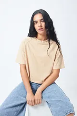 Remera negra de corte holgado con mangas ranglan y cuello redondo con bordado de estrellas blancas.