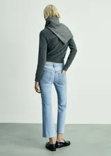 Jeans de tiro alto color celeste, corte flare, con cierre de cremallera y botón, cinco bolsillos, bajo deshilachado y tejido elástico.