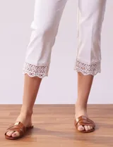 Pantalón capri negro de algodón con terminación de ruedo con aplique calado.