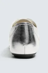 Zapatillas deportivas plateadas de cuero con efecto metalizado, cordones y suela plana. Diseño de punta redonda y colaboración especial Harry Lambert for Zara x Disney.