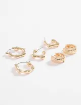 Set de tres pares de aros dorados con diferentes diseños: aros tipo argolla, aros cuadrados y aros hexagonales con incrustaciones de strass.