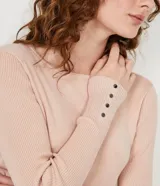 Suéter de punto color verde, con cuello barco, mangas largas y textura acanalada.