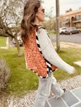 Chaleco color crema con ribete amarillo, de corte recto y sin mangas.