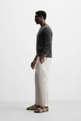 Pantalón de lino color marrón oscuro, de corte recto y relaxed fit. Tiene cintura elástica ajustable con cordón, bolsillos frontales y traseros de parche.