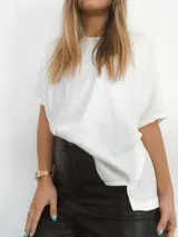 Remerón blanco de morley de algodón, manga corta, con dos pequeñas aberturas frontales y terminación en pico en la parte trasera.