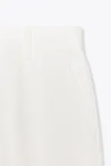 Pantalón de tiro medio confeccionado en hilatura de algodón color blanco. Cuenta con trabillas en la cintura, bolsillos laterales ocultos en costura y cierre frontal con cremallera, botón y ganchos metálicos.