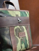 Mochila pequeña color borgoña con detalles en cuero marrón, asa de mano y correas ajustables.
