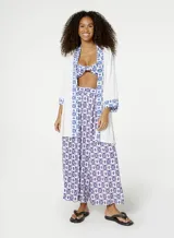 Kimono blanco con estampado de palmera azul en la espalda y detalles geométricos azules en los puños y el ruedo.