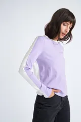 Remera de manga larga color lila con detalle de color block en mangas color blanco, cuello redondo y calce regular.
