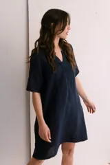 Vestido corto color arena, de lino, con escote en V y mangas cortas.