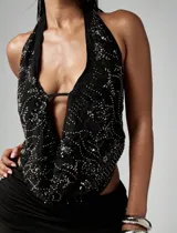 Top halter negro con escote pronunciado y espalda descubierta, confeccionado en tela con lentejuelas y cuentas plateadas.