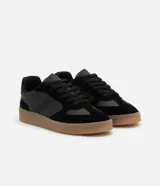 Championes urbanos de corte bajo, color blanco con detalles en gris y negro. Confeccionados en material sintético con recortes efecto gamuza y suela de látex color caramelo.