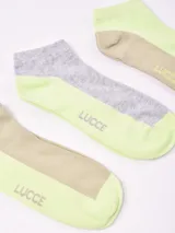 Pack de tres pares de soquetes tobilleros con diseño bicolor. Un par color beige con puntera y talón verde lima, un par gris con puntera y talón verde lima, y un par color beige con puntera y talón verde lima.