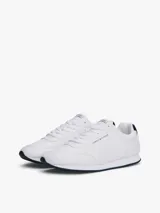 Zapatillas Tommy Hilfiger blancas de estilo running, con suela dentada fina y logo de la marca en el lateral.