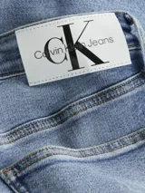 Jeans skinny de tiro bajo, color azul claro vintage con efecto desgastado y rotos en las piernas.