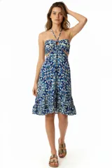 Vestido midi con estampado floral en tonos azules y blancos, con breteles finos que se atan al cuello, escote halter con abertura circular y corte en la cintura con aberturas laterales.