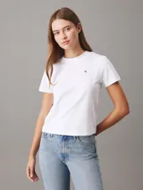 Remera blanca de algodón con cuello redondo, mangas cortas y corte relaxed. Presenta un pequeño logo de la marca bordado en el pecho y un estampado con el logo de Calvin Klein en la espalda.