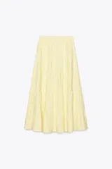 Falda larga color amarillo pastel, de tiro medio con cintura elástica ajustable con lazada y bajo acabado en paneles.