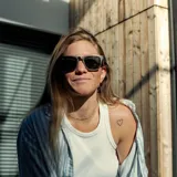 Lentes de sol con marco de madera color marrón y patillas de madera clara. Lentes verdes.