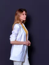 Blazer de lino color blanco, de corte recto y doble botonadura con botones color beige.